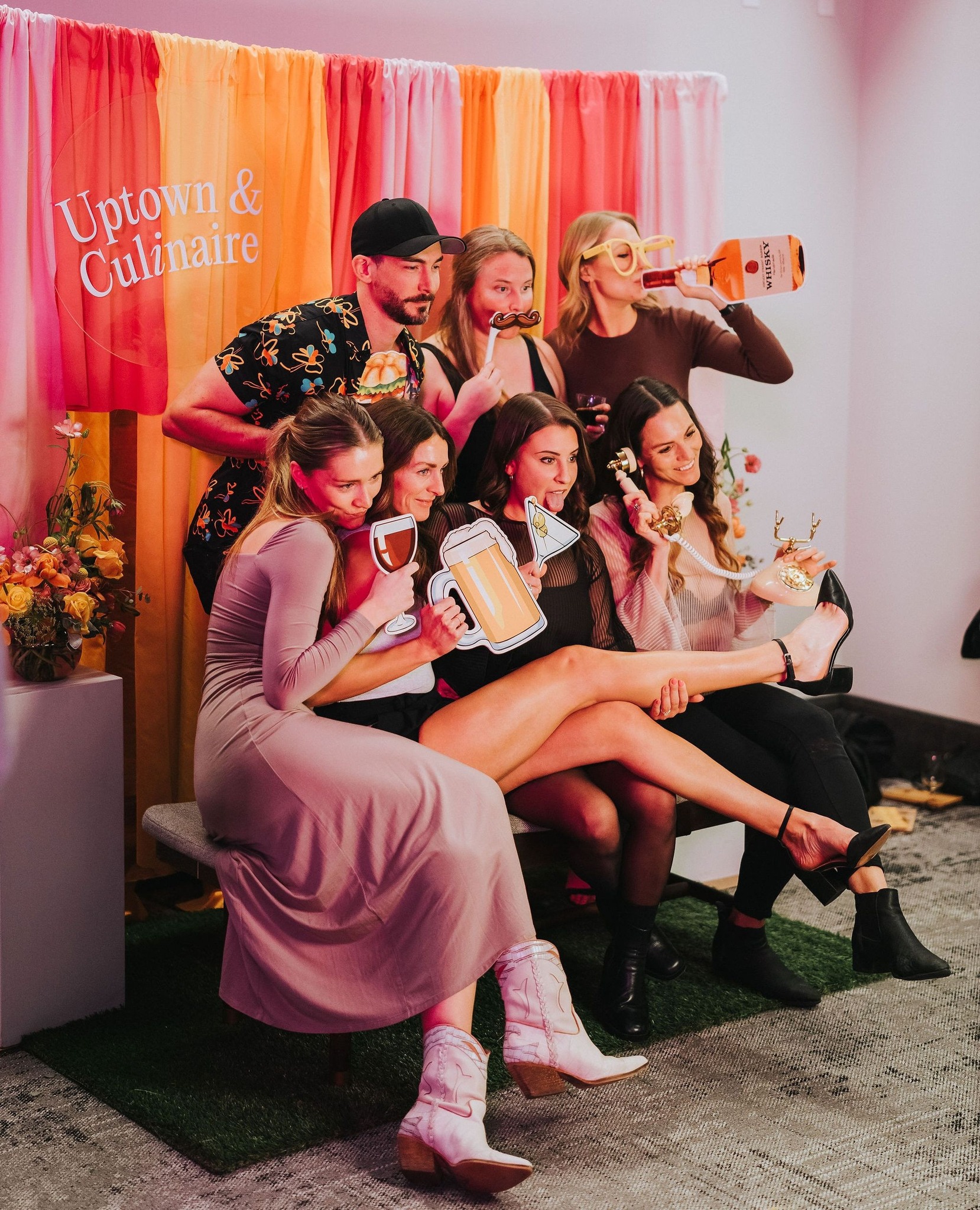 A group of people with fun props at a photo booth