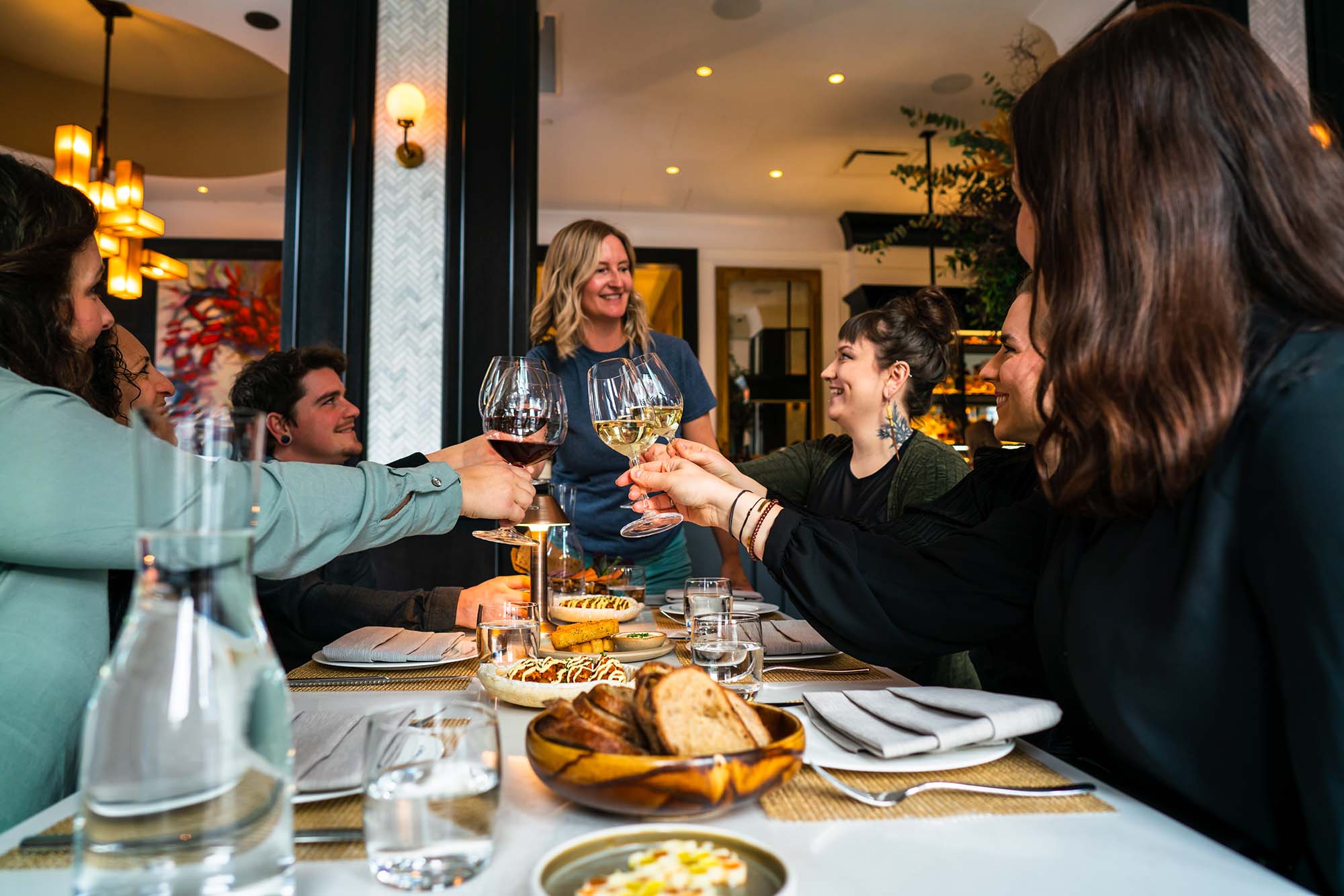 sitting around a table cheers with wine on fine dining evening tour victoria, bc